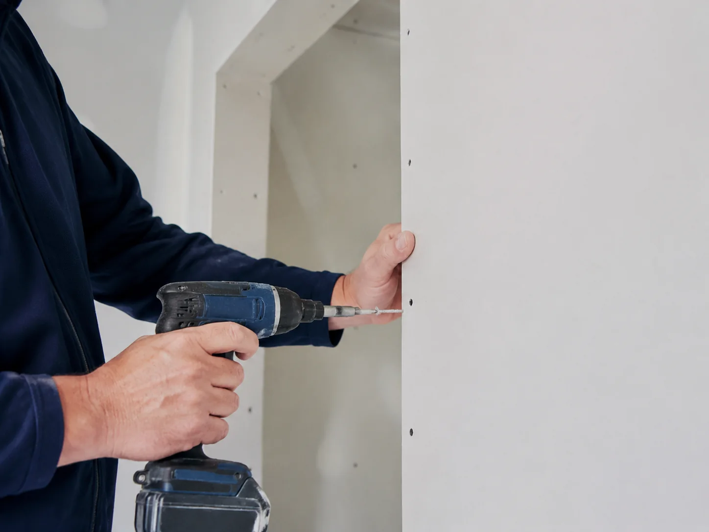 Contractor installing drywall